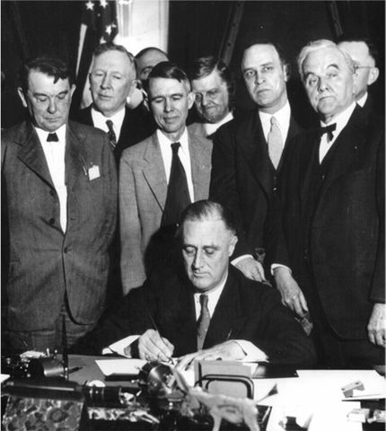 Roosvelt firma el Tennessee Valley Authority Act junto a sus consejeros en 1933