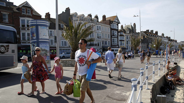 Los turistas caminan a lo largo de la playa en la ciudad de Dorset Weymouth, Inglaterra. El puerto fue el punto de partida para miles de tropas aliadas que participaron en el desembarco del Día D