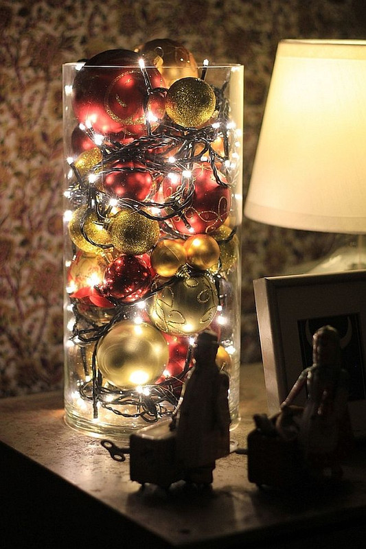 Christmas lights and ornaments in large cylinder vase