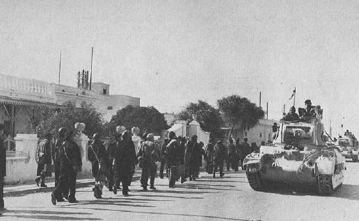 Las tropas de la Western Desert Force capturan Tobruk, enero de 1941. Una columna de tanques Matilda de la 7ª División Blindada pasa junto a una columna de prisioneros italianos